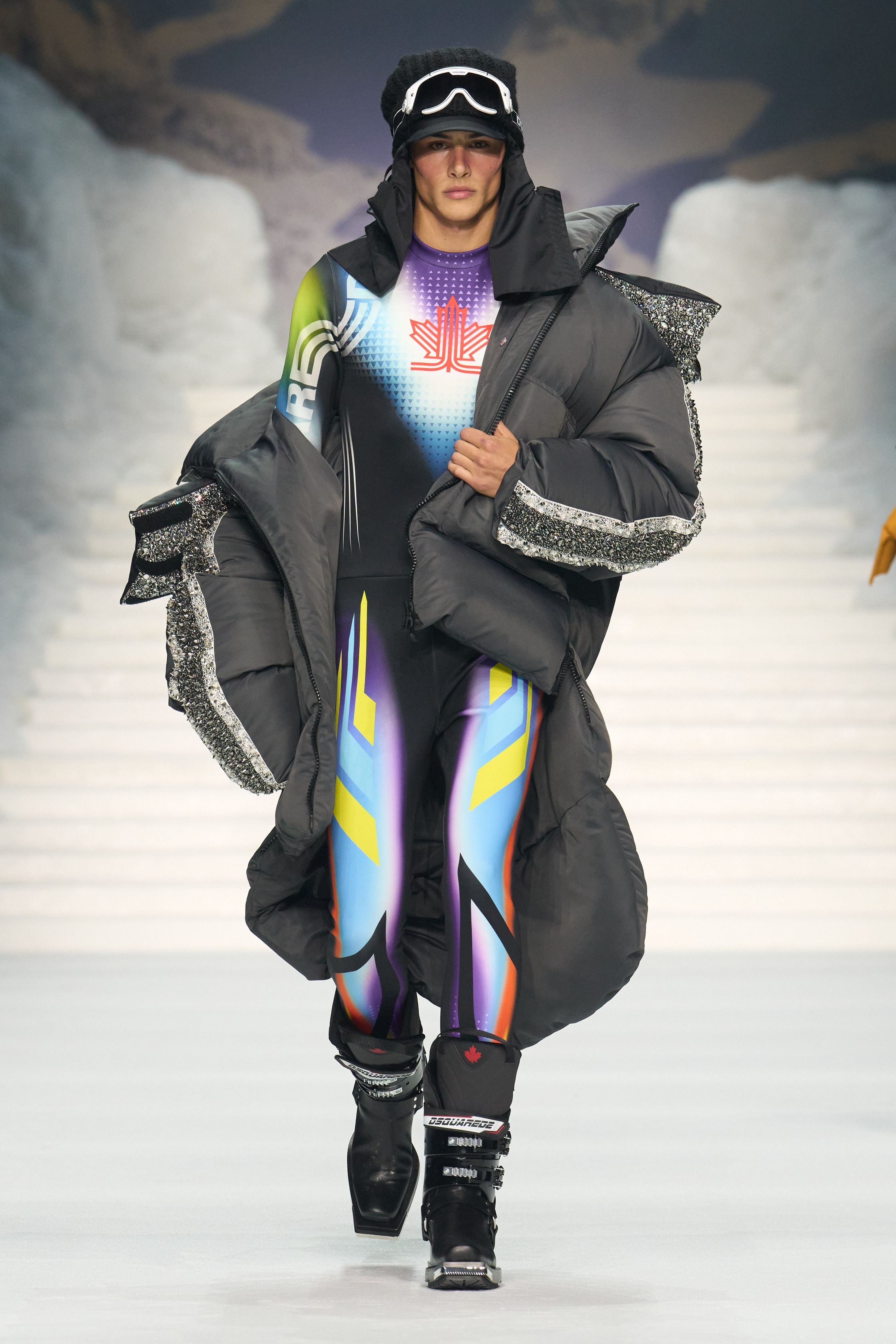 Dsquared2 2026秋冬以夸张的滑雪场景为背景，将加拿大户外精神、Y2K 性感与舞台化时装推至极致。羽绒、毛皮、紧身牛仔与夸张比例不断叠加，身体成为视觉焦点，性感、力量与炫耀被无限放大。这不是现实主义的衣橱，而是一场关于冒险、欲望与表演的时尚狂欢，张扬而直接，忠于品牌一贯的高能量叙事-顽石频道趋势研究